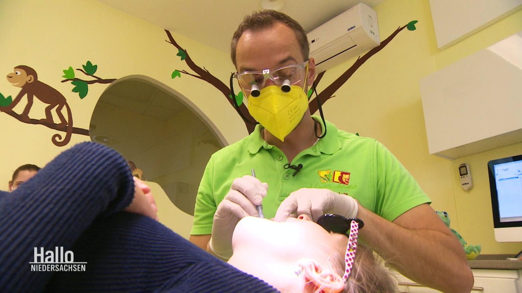 Ein Zahnarzt kontrolliert die Zähne eines Kindes. 