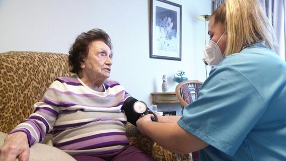 Pflegerin Mirnessa Tschibo misst Blutdruck bei einer Heimbewohnerin © Screenshot 