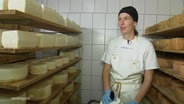 Eine Frau arbeitet in einer Käserei. © Screenshot 