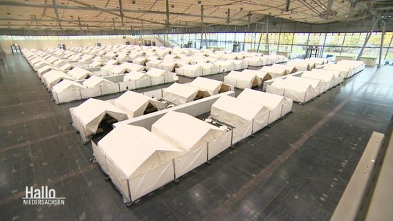 Zelte in einer Messehalle. © Screenshot 