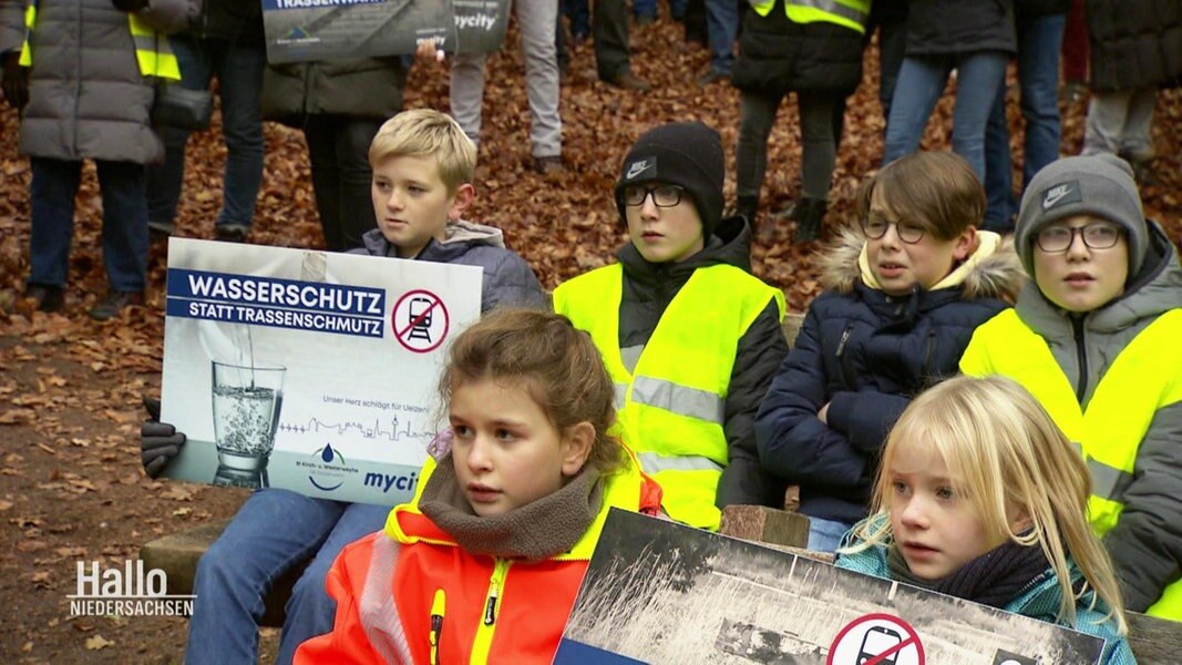 Kinder demonstrieren gegen eine Bahntrasse. 
