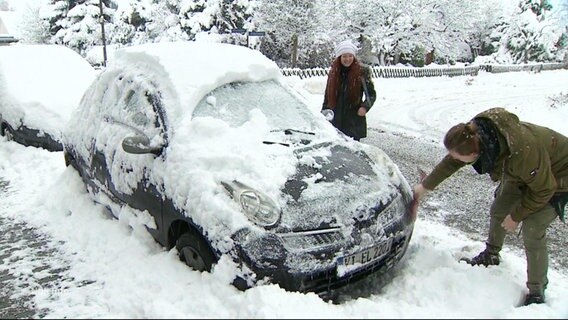 Ein Auto wird vom Schnee befreit. © Screenshot 