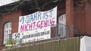 Ein Banner mit der Aufschrift: "1 Jahr ist nicht Genug" hängt auf einem Balkon © Screenshot 