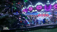 Ein bunt beleuchtetes Karussel dreht sich auf einem Weihnachtsmarkt © Screenshot 