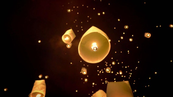 Leuchtende Lampions schweben in einen Nachthimmel. © Screenshot 