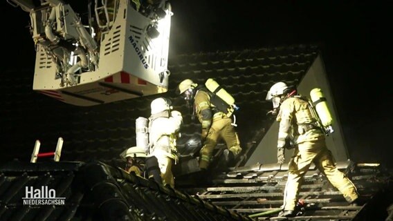 Einsatzkräfte auf dem Dach des brennenden Gebäudes © Screenshot 