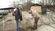 Zwei Fischer reparieren eine Aalreuse. © Screenshot 