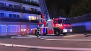 Ein Leiterwagen der Feuerwehr steht vor einem Haus. © Screenshot 