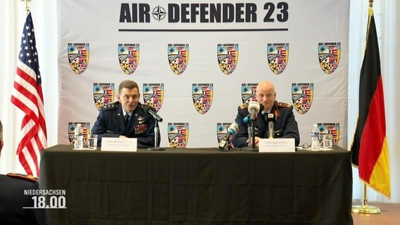Zwei Männer in Militärkleidung auf einer Pressekonferenz. © Screenshot 