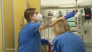 Zwei Krankenpflegerinnen stellen Instrumente auf einer Intensivstation ein. © Screenshot 
