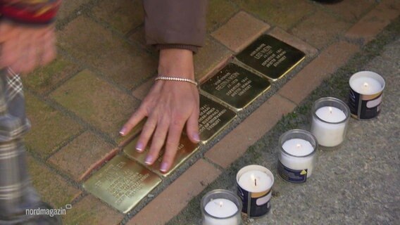 Eine Hand streicht über Stolpersteine in Stralsund. © Screenshot 