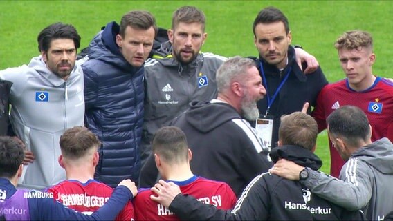 Die Spieler vom HSV stehen im Kreis und hören dem Trainer zu. © Screenshot 