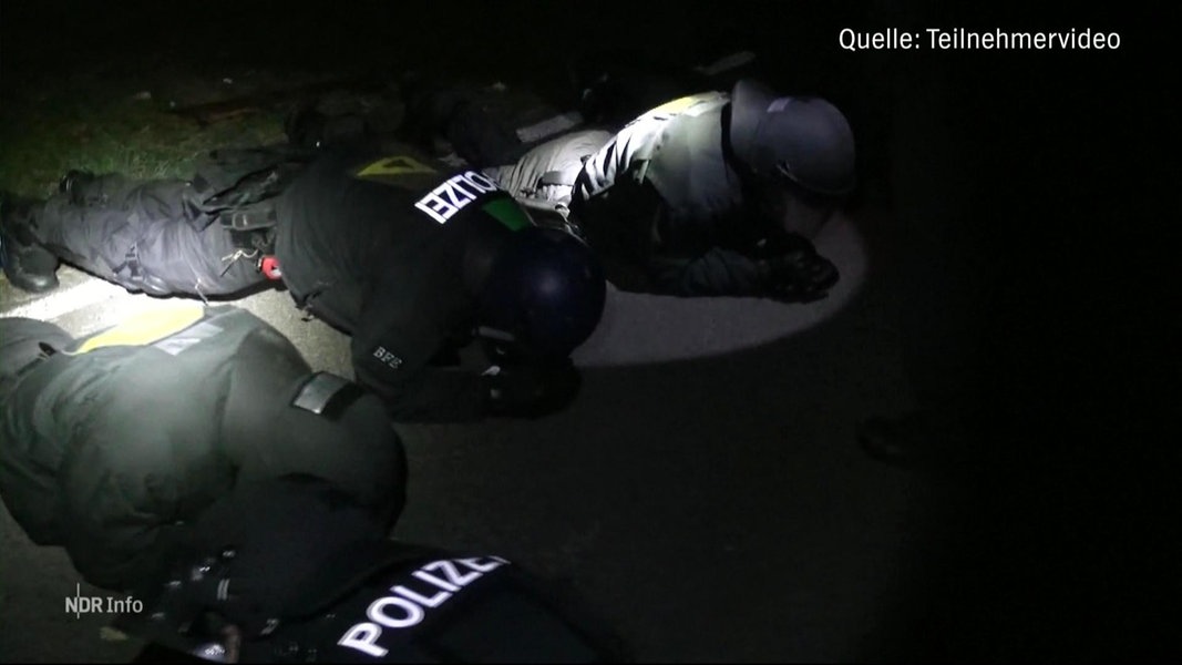 Bei einer nächtlichen Polizeiübung machen Einsatzkräfte der Polizei in voller Demo-Montur Liegestütze im Taschenlampenlicht.
