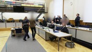 Szene aus dem Oberlandesgericht Koblenz: Ein Justizbeamter führt den Angeklagten in den Saal. © Screenshot 