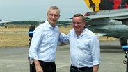 NATO-Generalsekretär Stoltenberg und Verteidigungsminister Pistorius posieren gemeinsam auf einem Militärflugplatz. © Screenshot 