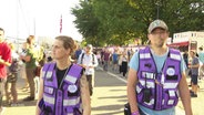 Zwei Personen des "Awareness-Teams" auf der Kieler Woche, erkennbar an lilanen Westen. © Screenshot 