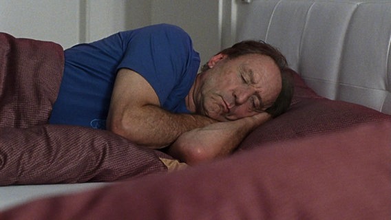 Alfons Keilinger liegt schlafend im Bett. © Screenshot 