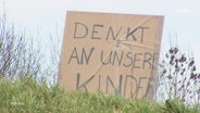 Ein Demonstrationsschild gegen den Bau einer Geflüchtetenunterkunft im Ort Upahl liest "Denkt an unsere Kinder." © Screenshot 