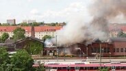 Das Dach des Eisenbahnmuseums in Schwerin brennt, es gibt eine starke Rauchentwicklung. © Screenshot 