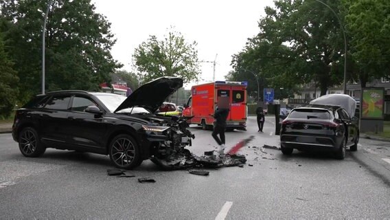 Zwei Pkw stehen mit einem Totalschaden auf der Straße. Im Hintergrund steht ein Rettungswagen. © TVNK 