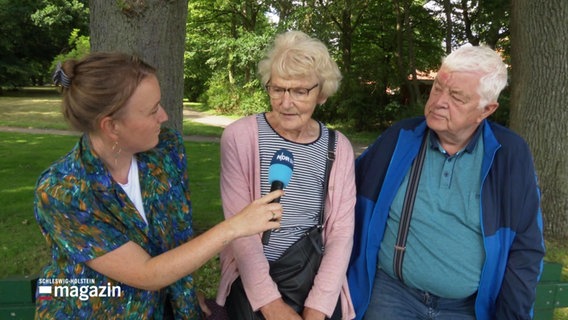 Eine Reporterin interviewt ein älteres Paar © Screenshot 