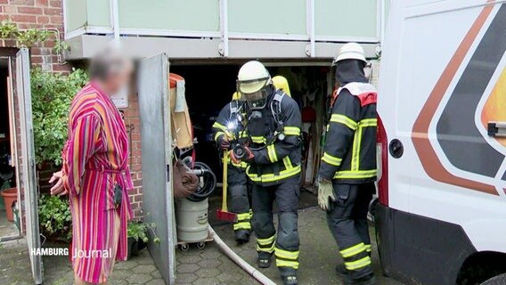 Feuerwehrleute evakuieren Menschen aus einem Wohnhaus. © Screenshot 