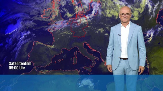 Wetterexperte Karsten Schwanke steht vor einer digitalen Wettertafel im Studio. © Screenshot 