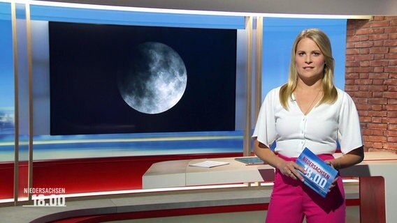 Nachrichtensprecherin Kathrin Kampmann, im Hintergrund ein Bild von einem Vollmond. © Screenshot 