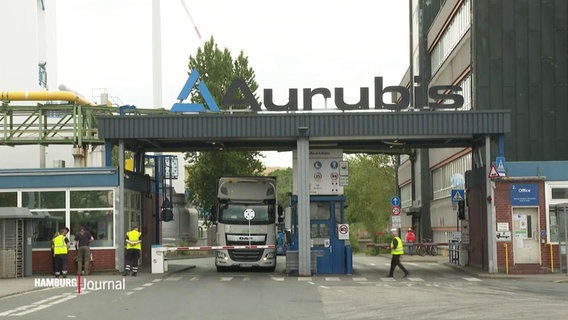 Die Firma Aurubis von Außen. Lkw stehen vor einer Schranke. © Screenshot 