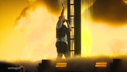 Der Rapper Marteria steht bei einem Konzert im Nebel auf der Bühne, hinter ihm eine LED-Wand. © Screenshot 