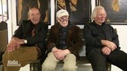 Drei ältere Herren sitzen auf Stühlen vor ihren Werken. © Screenshot 