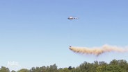 Mineralkalk wird mit Hilfe eines Hubschraubers über einem Wald verstreut. © Screenshot 
