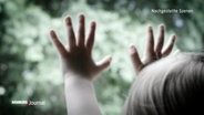 Nachgestellte Szene: ein Kleinkind hält seine Hände gegen eine Fensterscheibe. © Screenshot 