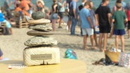 Ein Pokal aus Steinen mit der Aufschrift "Ditsch WM 2023" steht an einem Strand © Screenshot 