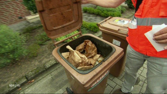 Eine Bio-Tonne wird auf anderen Müll kontrolliert. © Screenshot 