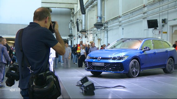 Mann fotografiert den neuen VW Tiguan auf der Betriebsversammlung des Konzerns. © Screenshot 