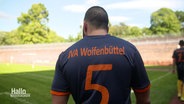 Der Rücken einer Person im Fußballtrikot der JVA Wolfenbüttel. © Screenshot 