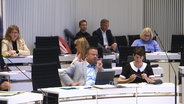 Menschen im Landtag auf Stühlen. © Screenshot 