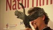 Der Gewinner des Darßer NaturfilmFestival, Regisseur Rubén Abruña, hält seine Auszeichnung. © Screenshot 