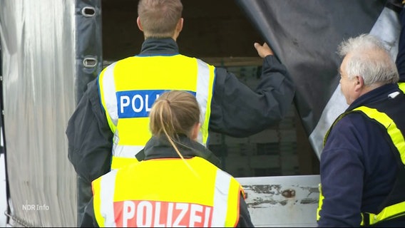 Polizisten kontrollieren die Ladung eines LKWs. © Screenshot 