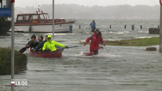 Während einer Sturmflut werden einige Männer in einem Boot gezogen. © Screenshot 
