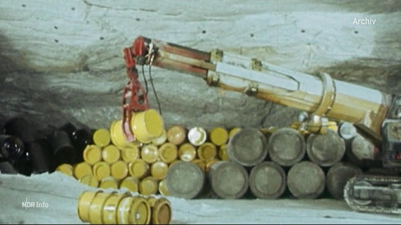Archivbild: Gelbe Fässer werden in einem Stollen von einem Kran gestapelt. © Screenshot 