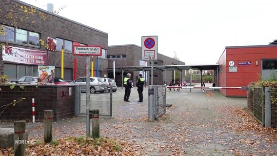 Zwei Polizisten auf einem Schulhofgelände. © Screenshot 