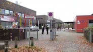 Zwei Polizisten auf einem Schulhofgelände. © Screenshot 