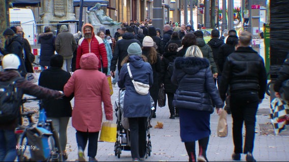 Menschen gehen in einer Fußgängerzone. © Screenshot 