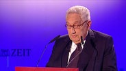 Henry Kissinger am Rednerpult. © Screenshot 