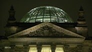 Das Gebäude des Deutschen Bundestages mit der typischen Glaskuppel, beleuchtet bei Dunkelheit. © Screenshot 