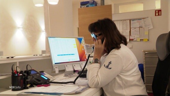 Eine Frau im weißen Kittel telefoniert an einem Schreibtisch. © Screenshot 