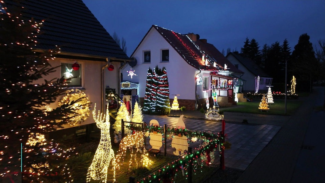 Zwei Häuser mit sehr viel Weihnachtsbeleuchtung.