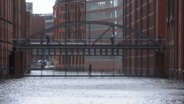 Eine Brücke in der Hamburger Speicherstadt. Das Wasser steht so hoch, dass es fast die Brücke erreicht. © Screenshot 